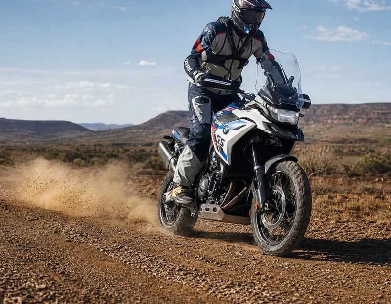 An adventure bike kicking up dust on a dirt road